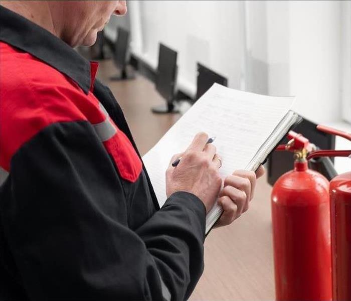 Man holding paperwork and reviewing list